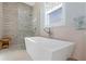 Close-up of the soaking tub and glass-enclosed shower with modern fixtures in the bright bathroom at 230 Tucker St, Safety Harbor, FL 34695