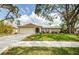 Charming single-story home featuring a well-maintained lawn and a two-car garage with a stone accent wall at 280 Cherry Laurel Dr, Palm Harbor, FL 34683