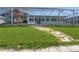 Backyard with grass and stone paver path to screened-in outdoor seating and pool area at 2821 Coral Way, Punta Gorda, FL 33950