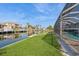 Backyard on the water with a screened-in pool, manicured lawn, dock, and waterfront views at 2821 Coral Way, Punta Gorda, FL 33950