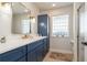 Bathroom showcasing a blue vanity with gold fixtures and a glass block window at 2821 Coral Way, Punta Gorda, FL 33950