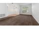 Open-concept living room with tile entry, neutral carpeting, a modern chandelier, and a bright window at 34822 Marsh Glen Ct, Zephyrhills, FL 33541