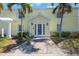 Charming yellow condo exterior with lush landscaping and a welcoming double-door entrance at 5092 Beach Se Dr # D, St Petersburg, FL 33705