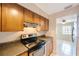 Functional kitchen featuring dark countertops, wooden cabinets, and stainless steel appliances at 5092 Beach Se Dr # D, St Petersburg, FL 33705