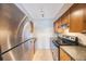 Galley kitchen featuring stainless steel appliances, wood cabinets and tile flooring at 5092 Beach Se Dr # D, St Petersburg, FL 33705
