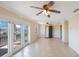 Open living area with tiled floor, ceiling fans, and sliding glass doors to the outside balcony at 5092 Beach Se Dr # D, St Petersburg, FL 33705