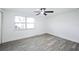 Bright bedroom featuring a ceiling fan, large window, and light-colored laminate flooring at 6304 Seabreeze Dr, Port Richey, FL 34668