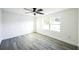 Bright, freshly painted bedroom with a ceiling fan, a large window, and light-colored wood flooring at 6304 Seabreeze Dr, Port Richey, FL 34668