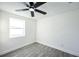 Bright, freshly painted bedroom with a ceiling fan and light-colored wood flooring at 6304 Seabreeze Dr, Port Richey, FL 34668