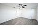 White bedroom featuring a ceiling fan, doorway, and light-colored laminate flooring at 6304 Seabreeze Dr, Port Richey, FL 34668