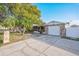 Beautiful single-Gathering home with stone details, mature trees, and a driveway leading to the attached garage at 6304 Seabreeze Dr, Port Richey, FL 34668
