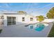 Relaxing pool with blue tile trim, surrounded by a concrete patio and a beautiful tropical palm tree at 6304 Seabreeze Dr, Port Richey, FL 34668