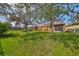 Large grassy backyard featuring mature trees, a view of neighboring properties, and a serene setting at 715 Parker Den Dr, Ruskin, FL 33570