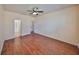 Bedroom featuring wood floors, a ceiling fan, and two doors leading to a walk-in closet and hallway at 715 Parker Den Dr, Ruskin, FL 33570