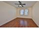 Bedroom with wood floors, ceiling fan and light, and two windows with blinds and a view of trees at 715 Parker Den Dr, Ruskin, FL 33570