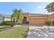 Charming single-story home with a well-manicured lawn, palm tree, and neutral-tone exterior at 715 Parker Den Dr, Ruskin, FL 33570