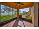 Relaxing screened porch with ceiling fan, offering serene views of the lake and landscaped backyard at 715 Parker Den Dr, Ruskin, FL 33570