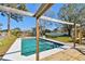 Wooden deck and frame overlook backyard in-ground pool with fenced yard and mature trees at 8555 81St Way, Largo, FL 33777