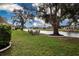 Serene backyard with a waterfront view, mature trees, and outdoor seating area at 2016 E View Dr, Sun City Center, FL 33573