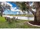 Picturesque waterfront view from the backyard, showcasing mature trees and well-maintained landscaping at 2016 E View Dr, Sun City Center, FL 33573