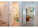 Hallway between closet, bathroom, and bedroom, all featuring consistent light hardwood flooring at 2016 E View Dr, Sun City Center, FL 33573