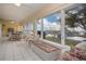 Spacious sunroom with tile flooring, dining area, white wicker furniture, and a view of the waterfront at 2016 E View Dr, Sun City Center, FL 33573