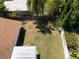 Aerial view of a grassy backyard with a rustic wooden fence and some mature trees; a well maintained lawn is visible at 2391 66Th S Ter, St Petersburg, FL 33712