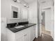 Well-lit bathroom featuring a granite countertop, white cabinetry, and minimalist decor at 2391 66Th S Ter, St Petersburg, FL 33712