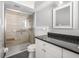 Modern bathroom with a sleek glass-enclosed shower, tiled walls, and a vanity with a dark countertop at 2391 66Th S Ter, St Petersburg, FL 33712