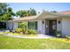 Inviting single-story home with a well-kept lawn, swaying palms, and covered entrance at 2391 66Th S Ter, St Petersburg, FL 33712