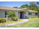 Charming home featuring a covered entrance, updated facade, and colorful landscaping at 2391 66Th S Ter, St Petersburg, FL 33712