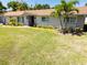 Well-kept front yard featuring a lush green lawn, mature palm trees, and manicured landscaping at 2391 66Th S Ter, St Petersburg, FL 33712