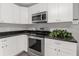 Modern kitchen showcasing stainless steel oven, microwave, and sleek white cabinetry at 2391 66Th S Ter, St Petersburg, FL 33712