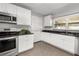 Well-lit kitchen with stainless steel appliances, granite counters, and white cabinetry at 2391 66Th S Ter, St Petersburg, FL 33712