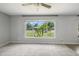 Living room with neutral gray carpet, paint, ceiling fan, and a view of the outdoors at 2391 66Th S Ter, St Petersburg, FL 33712