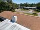 Aerial shot of a shingled roof with a white chimney and surrounding green landscape at 2391 66Th S Ter, St Petersburg, FL 33712