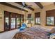 Comfortable bedroom with wooden beams, king bed, and patio access at 33642 Blanton Rd, Dade City, FL 33523