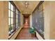 Long hallway with terracotta tile floors, large windows, and decorative lighting at 33642 Blanton Rd, Dade City, FL 33523