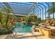Resort-style pool with covered patio, waterfall, and lush landscaping at 33642 Blanton Rd, Dade City, FL 33523