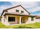 Tan house with brown roof, covered patio, and grassy backyard at 11468 Weaver Hollow Rd, New Port Richey, FL 34654