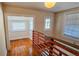 Hallway with hardwood floors, bright natural light, and a charming orange-toned wooden railing at 1414 7Th S St, St Petersburg, FL 33701