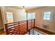 Hallway with open doorways, hardwood floors, wooden railing and a hanging globe light at 1414 7Th S St, St Petersburg, FL 33701