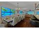 Elegant dining room features a large table, chandelier, and beach-themed art at 3087, 3075 Cherry Ln, Clearwater, FL 33759