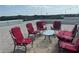 Rooftop terrace with red chairs and glass-top table at 3087, 3075 Cherry Ln, Clearwater, FL 33759