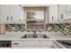 Kitchen with white cabinets, stainless steel sink, and mosaic backsplash at 300 6Th N St # 8, Safety Harbor, FL 34695
