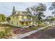 Front view of the yellow house, with brick driveway and mature trees at 553 Division St, Tarpon Springs, FL 34689