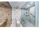 Modern bathroom featuring marble tile, a glass-enclosed shower, and updated fixtures at 634 Edgewater Dr # 644, Dunedin, FL 34698