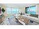 Bright living room with a large sectional sofa and sliding doors opening to scenic ocean views at 634 Edgewater Dr # 644, Dunedin, FL 34698