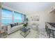 Bright living room features a large window with water views, neutral furniture, and marble floors at 634 Edgewater Dr # 644, Dunedin, FL 34698