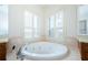 Relaxing bathroom with corner soaking tub and neutral color scheme at 1500 Ember Ln, Tarpon Springs, FL 34689